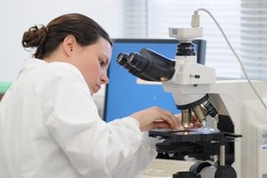 woman looking at something on a microscope